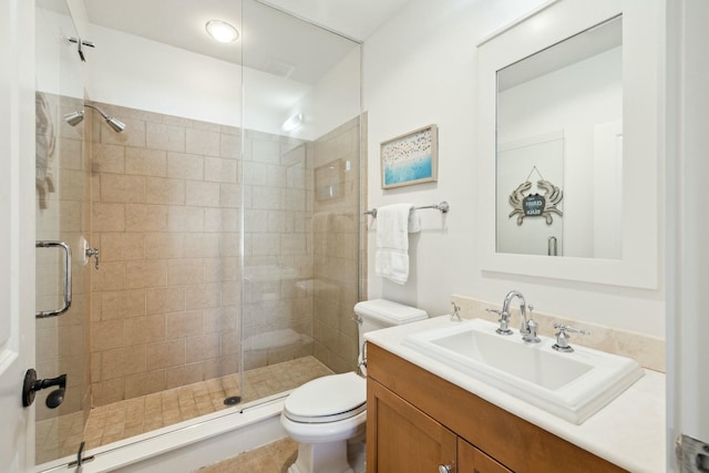 full bathroom featuring a shower stall, toilet, and vanity