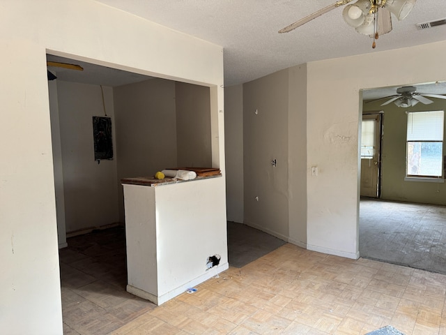 interior space featuring visible vents, a textured ceiling, ceiling fan, and light floors