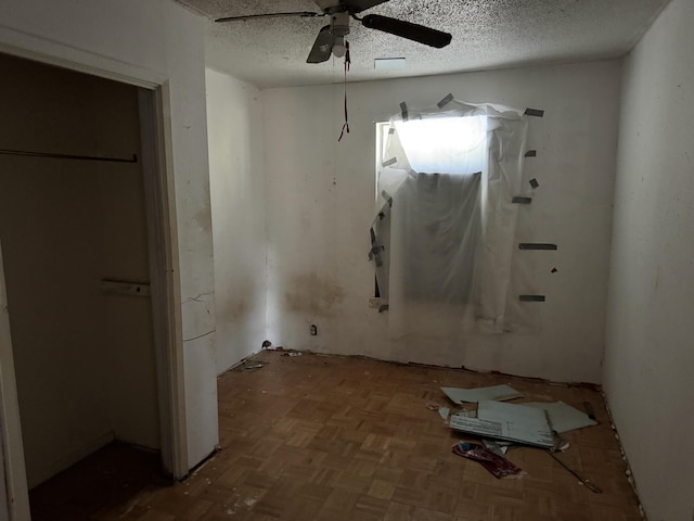 unfurnished bedroom with a ceiling fan and a textured ceiling