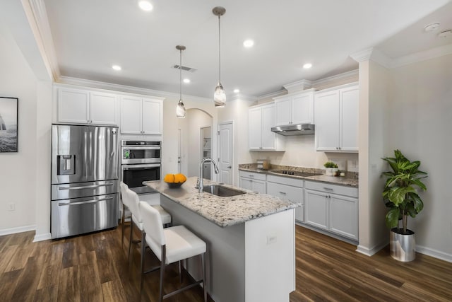 kitchen featuring arched walkways, visible vents, appliances with stainless steel finishes, a sink, and under cabinet range hood