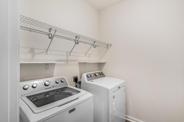 laundry room featuring laundry area, baseboards, and washing machine and clothes dryer