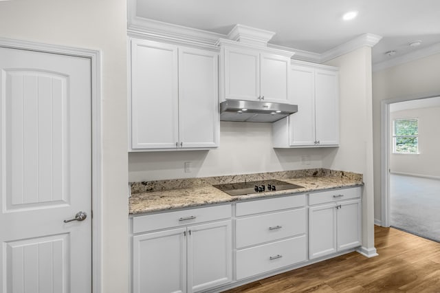 kitchen with white cabinets, wood finished floors, black electric cooktop, crown molding, and under cabinet range hood