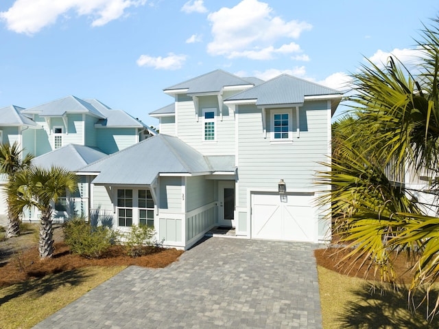 view of front of home with metal roof, decorative driveway, and a garage