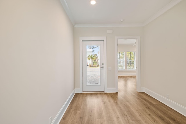 foyer entrance with light wood finished floors, crown molding, and baseboards