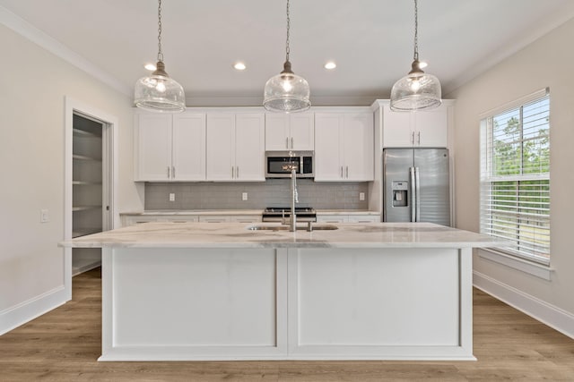 kitchen with a sink, white cabinets, a kitchen island with sink, and stainless steel appliances