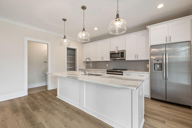 kitchen featuring light wood finished floors, white cabinets, appliances with stainless steel finishes, and a sink