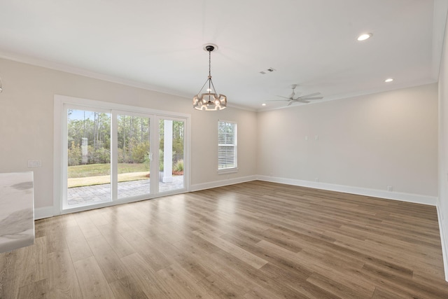 empty room featuring crown molding, baseboards, recessed lighting, ceiling fan with notable chandelier, and wood finished floors