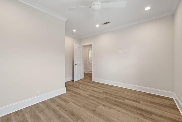 empty room featuring visible vents, crown molding, light wood finished floors, baseboards, and ceiling fan