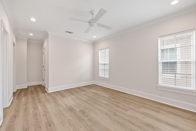 spare room with baseboards, light wood-style floors, visible vents, and ornamental molding