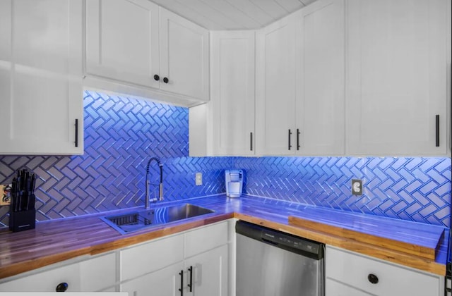 kitchen with butcher block countertops, white cabinets, dishwasher, and a sink