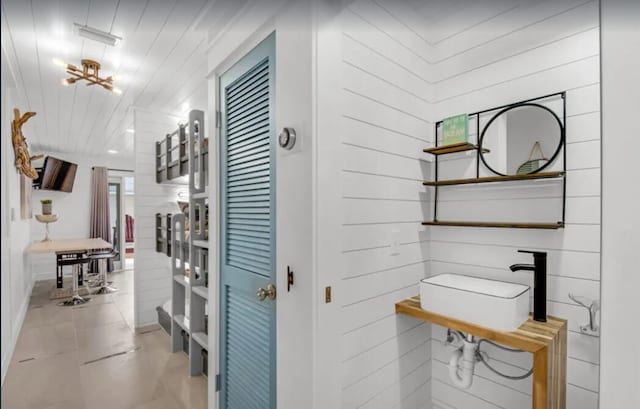 bathroom with a chandelier, tile patterned flooring, and a sink