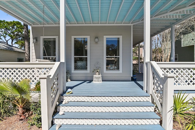 entrance to property featuring covered porch and metal roof