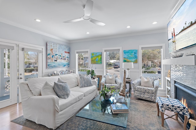 living area featuring recessed lighting, ornamental molding, wood finished floors, and a tile fireplace