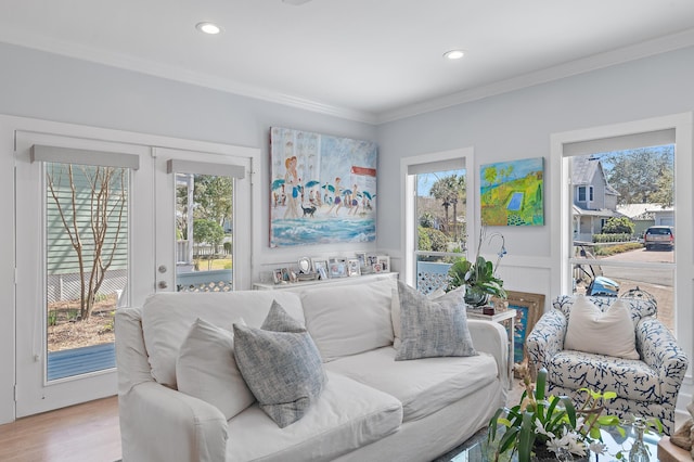 living room featuring light wood-type flooring, crown molding, and recessed lighting