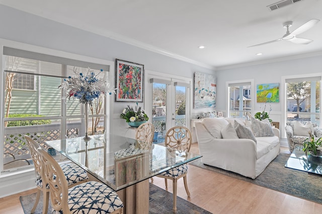 dining area with ornamental molding, a ceiling fan, visible vents, and wood finished floors