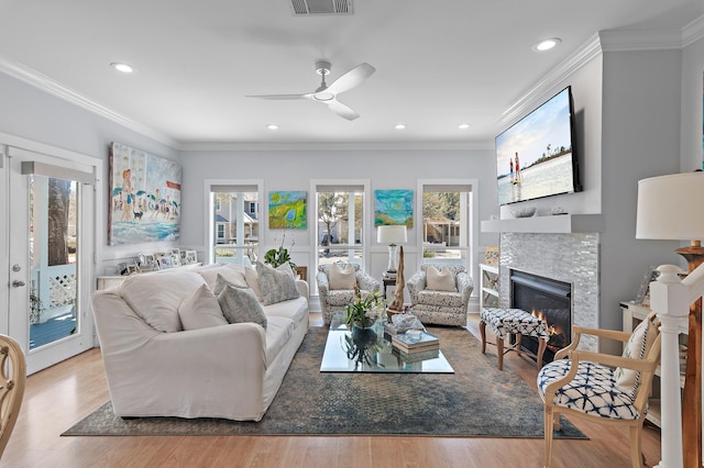 living room with ornamental molding, recessed lighting, a fireplace, and wood finished floors