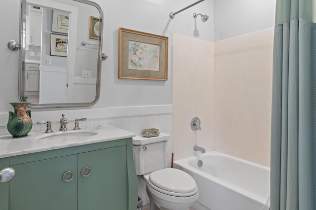 bathroom with toilet, a wainscoted wall, shower / bath combination with curtain, and vanity