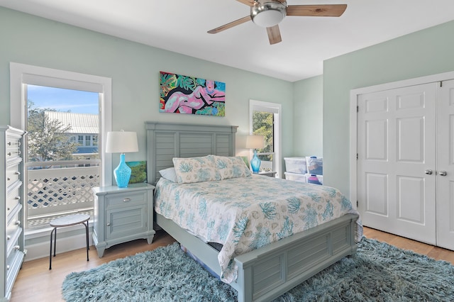 bedroom with light wood-style floors, multiple windows, and a ceiling fan