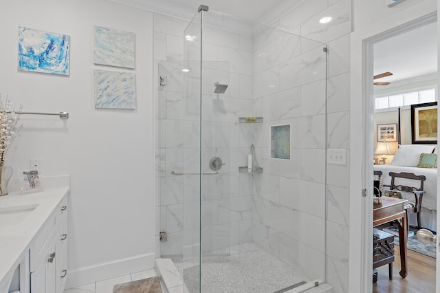 full bathroom featuring a shower stall, baseboards, crown molding, and vanity