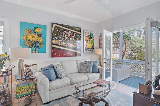 living area featuring french doors, ornamental molding, wood finished floors, and a ceiling fan