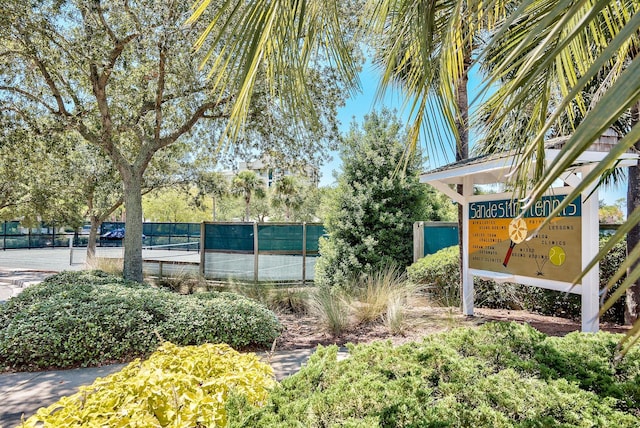 view of home's community featuring a tennis court and fence