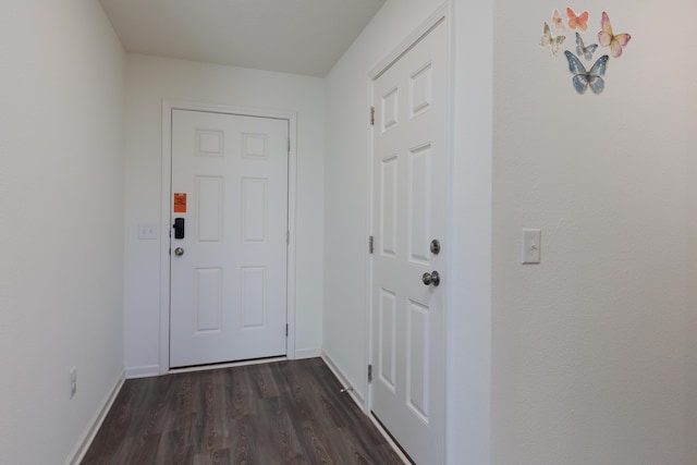 doorway with dark wood-type flooring and baseboards