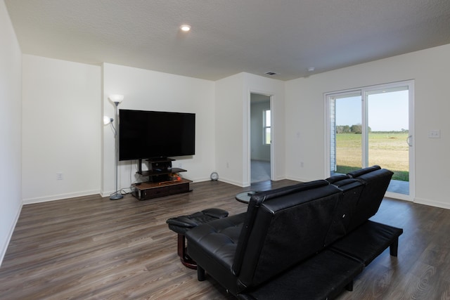 living room featuring a textured ceiling, wood finished floors, and baseboards