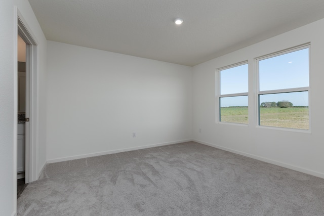 unfurnished room featuring carpet floors and baseboards