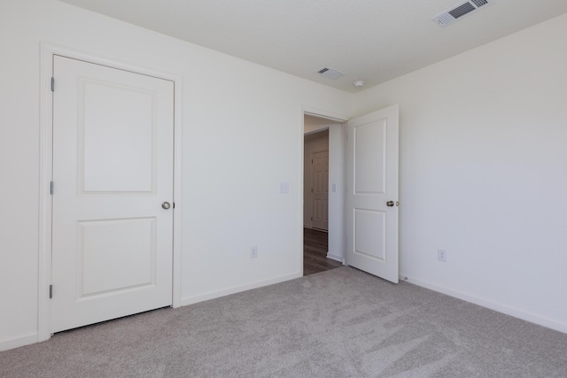 unfurnished bedroom featuring carpet flooring, visible vents, and baseboards