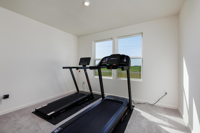 exercise room with carpet floors and baseboards