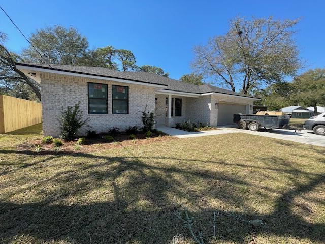 ranch-style home with a garage, brick siding, fence, concrete driveway, and a front yard