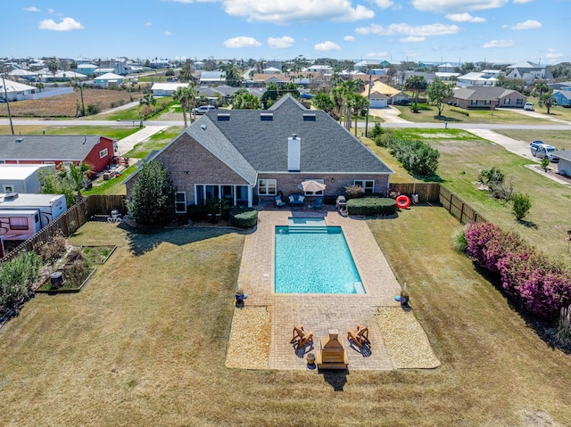 view of pool featuring a patio, a yard, a fenced backyard, and a residential view