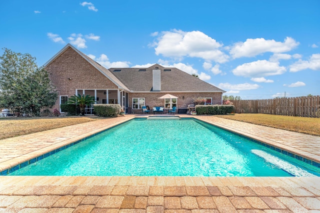 view of pool with a lawn, fence, a fenced in pool, and a patio