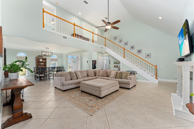 living room with baseboards, stairway, light tile patterned flooring, high vaulted ceiling, and ceiling fan with notable chandelier