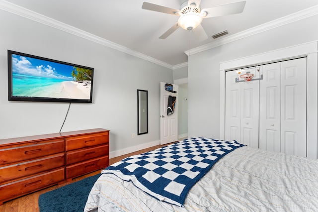 bedroom with ceiling fan, visible vents, baseboards, ornamental molding, and a closet