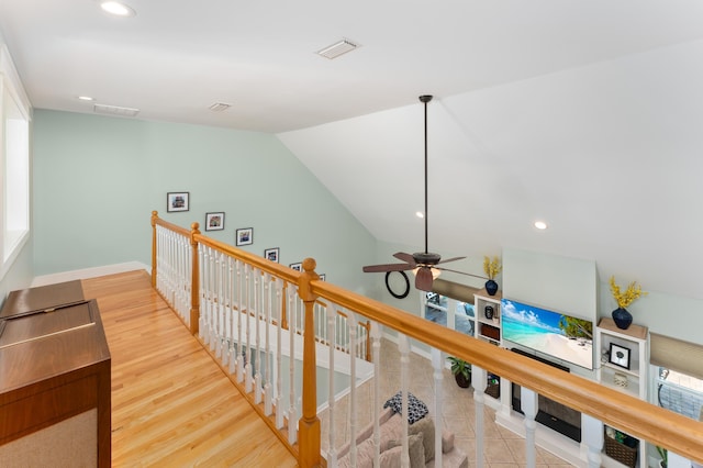 hall with recessed lighting, visible vents, an upstairs landing, and wood finished floors