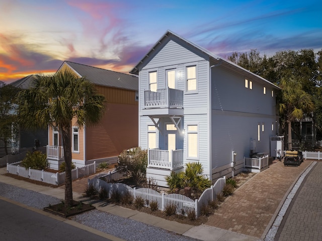 view of front of house with a fenced front yard and a balcony