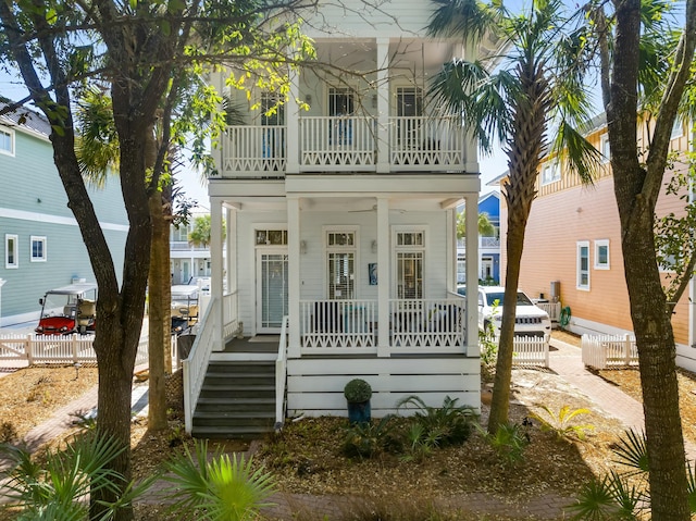 view of front of house featuring a porch, a balcony, and fence