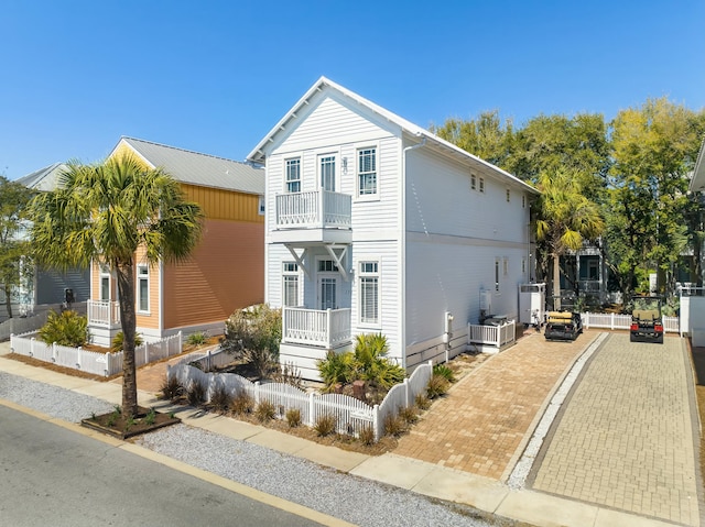 view of front of property with a balcony and a fenced front yard