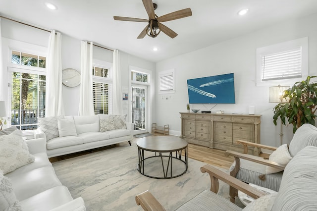 living area with a wealth of natural light, light wood-type flooring, and recessed lighting