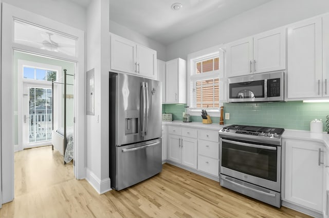 kitchen with decorative backsplash, light wood-style flooring, appliances with stainless steel finishes, and light countertops