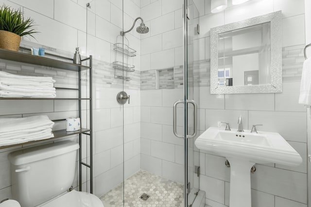 full bath featuring tasteful backsplash, toilet, tile walls, and a shower stall