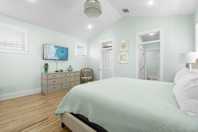 bedroom featuring multiple windows, light wood-type flooring, baseboards, and vaulted ceiling