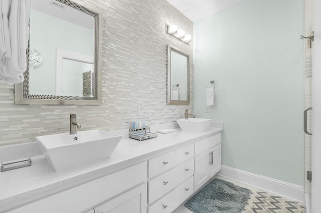 bathroom featuring tasteful backsplash, double vanity, baseboards, and a sink