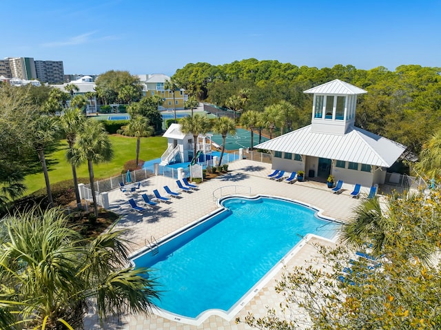 pool with a patio area and fence