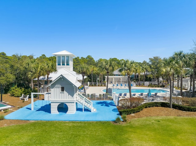 exterior space featuring a pool and a lawn