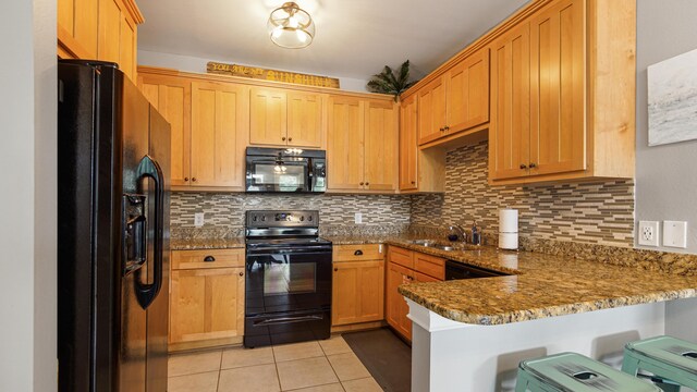 20 N Wildflower Dr Unit 512, Santa Rosa Beach, FL 32459 - kitchen featuring backsplash, a peninsula, light tile patterned flooring, black appliances, and a sink