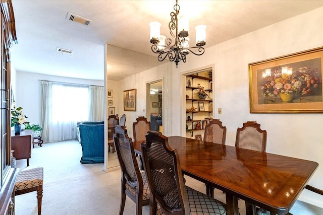 dining space with a chandelier, visible vents, and light colored carpet