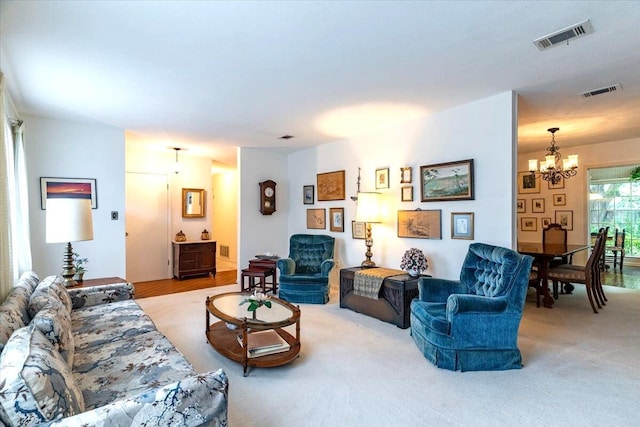 living area featuring light carpet, an inviting chandelier, and visible vents