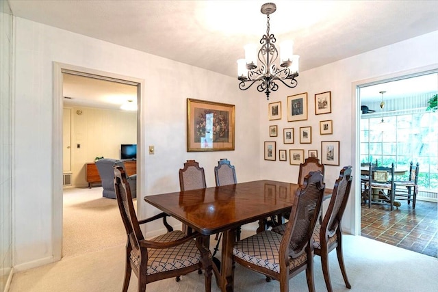 dining area with an inviting chandelier, baseboards, visible vents, and carpet flooring